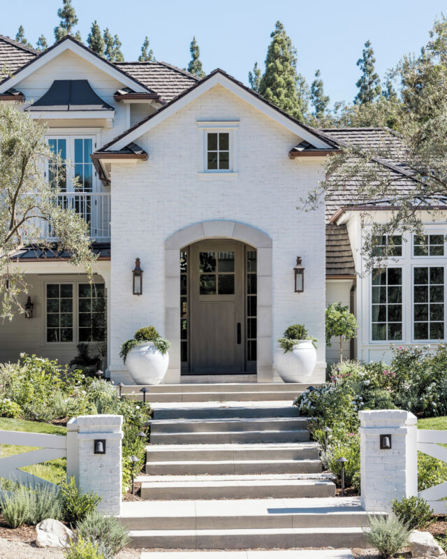 Timeless curb appeal at #mgdxnelliegail, clad with horizontal lap siding and brick in a soft white hue. #mindygayerdesign { Image by: @vlentine }⁣
⁣
#californiahomes #exteriordesign #homeexterior #exteriorpaint #exteriorstyle #houseexterior #californiahome #mybhghome #housetour #smmakelifebeautiful