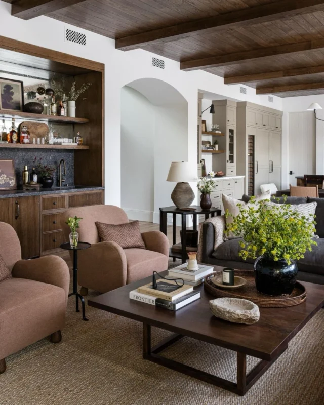 The great room at #mgdxpaseoclemente was imagined as one expansive, open space where family and friends can walk in, pour a drink, and settle in. Rather than lighten everything against the dark floors and ceilings, we leaned into contrast - Richer upholstery, layered woods, and a bold bar moment that feels inviting. There’s so much more to share from this space - Head to Substack for the full story! #mindygayerdesign { Image by: @vlentine, Architect: @brandonarchitects, Builder: @sayerandsons }